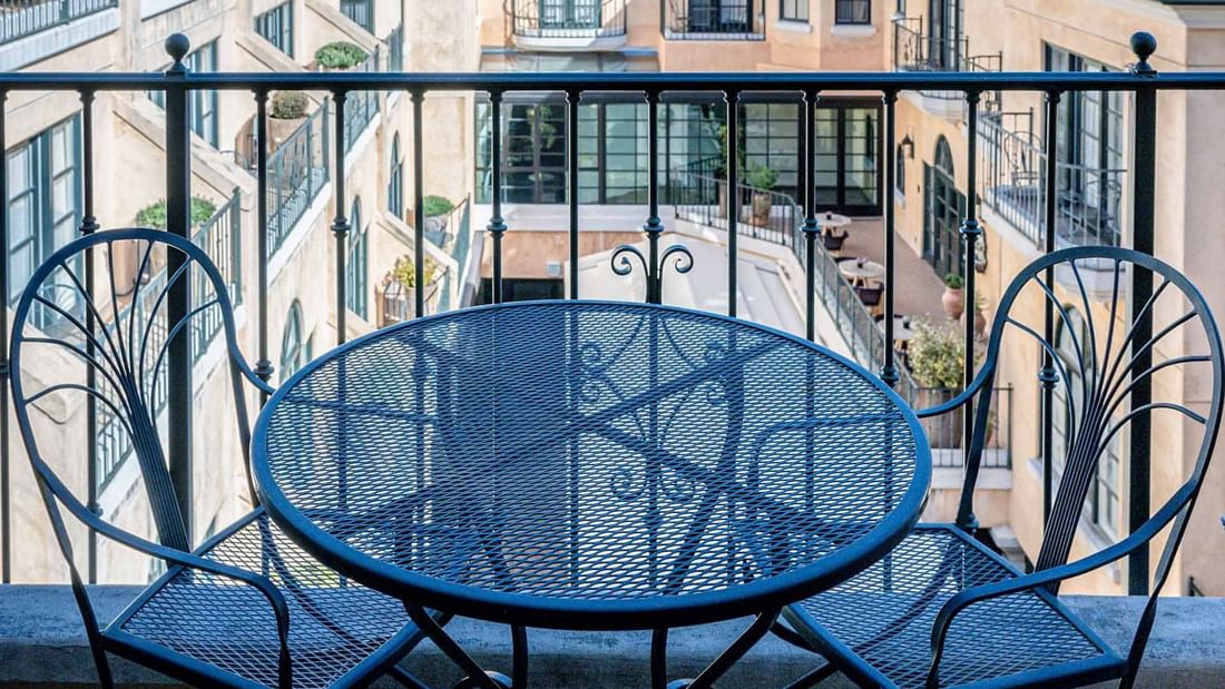 Charming balcony in Courtyard Grand Executive King Suite with a wrought iron table and chairs at El Prado Hotel