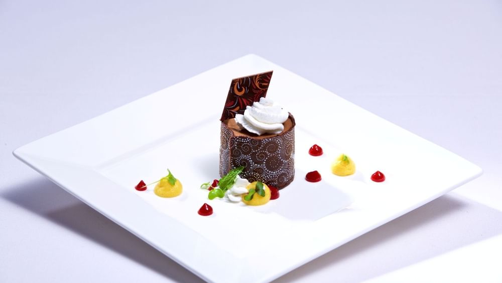 Chocolate dessert with mango coulis under whipped cream in Abbiocco at Warwick Paradise Island Bahamas