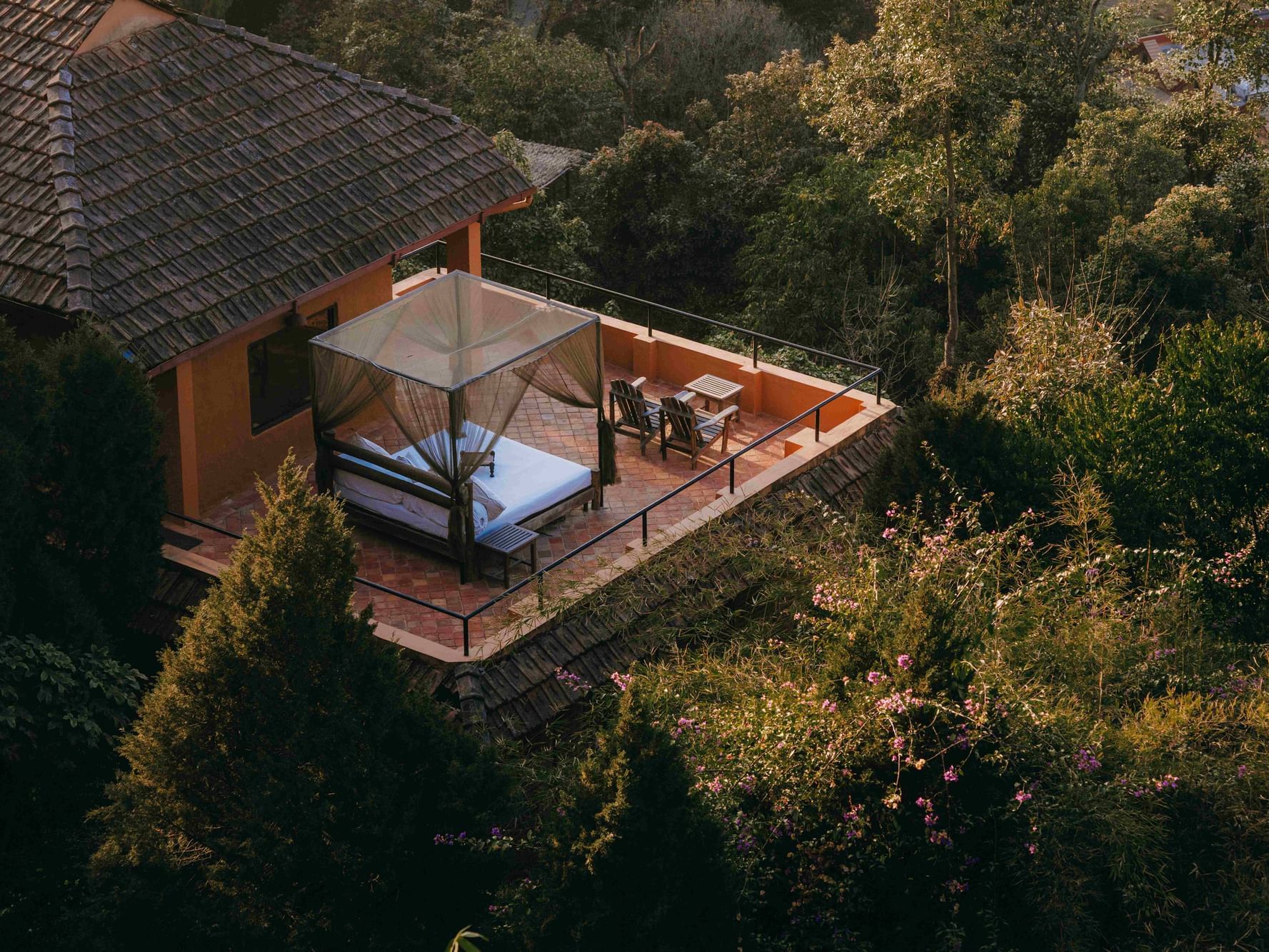 Executive Suite with Terrace with a bed under a canopy, surrounded by lush greenery at Dwarika's Himalayan Wellbeing