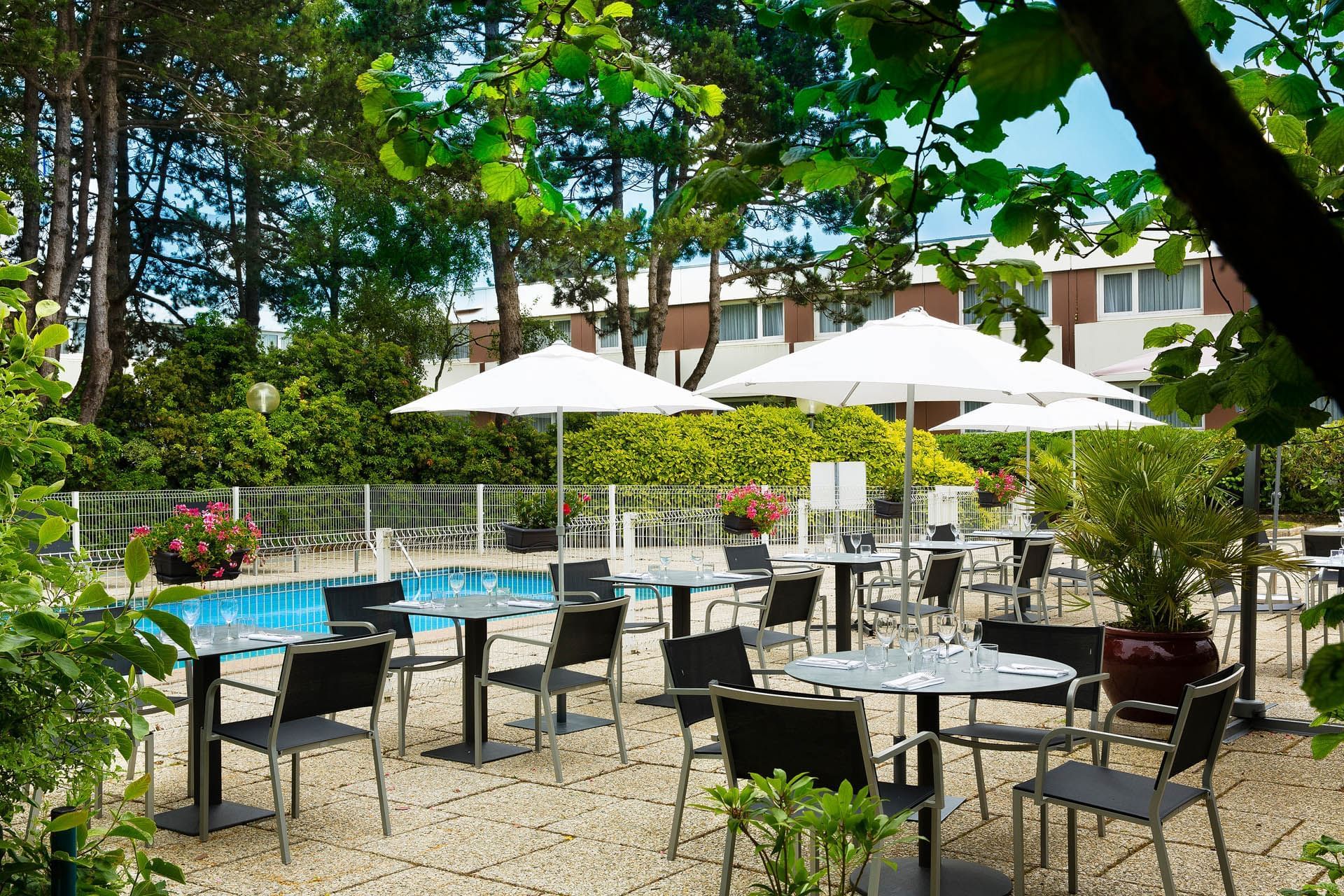 Espace salle à manger et salon près de la piscine à l'Escale Oceania Brest Aéroport
