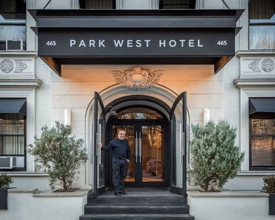 man holding open the door to a New York City hotel