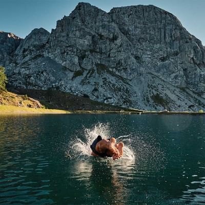 A man jumping into the water near Falkensteiner Hotels