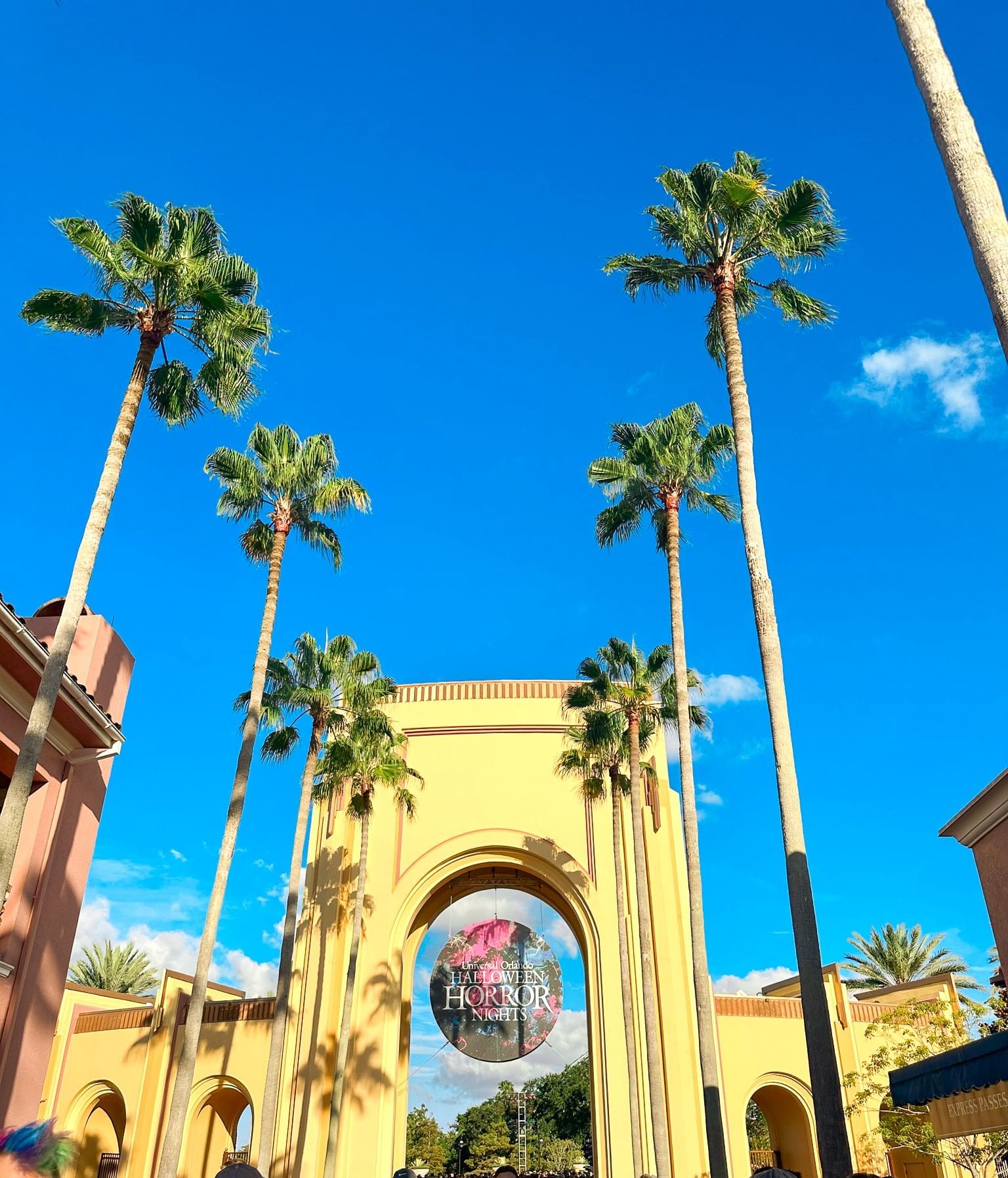 The front entry tower to Universal Studios Orlando during the daytime with a Halloween Horror Nights sign. 
