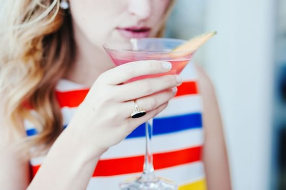 Young woman sipping a cocktail