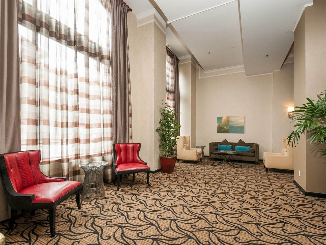 Lounge area with red chairs and a couch in the background at Pickwick San Francisco.