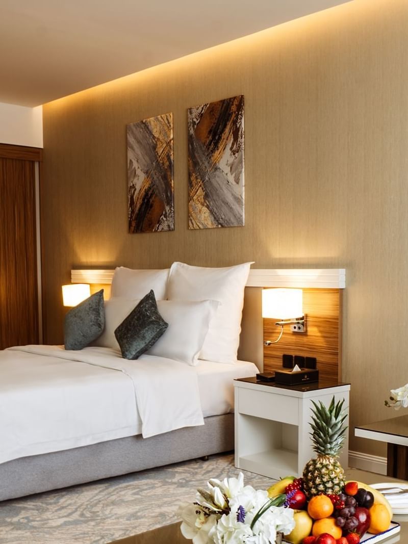 Standard Room features Plush bed by a nightstand under abstract art at Cantonal Hotel by Warwick Riyadh