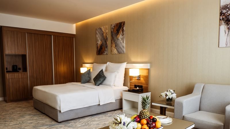 Table with fruits with cozy bed in Standard Room at Cantonal Hotel by Warwick Riyadh