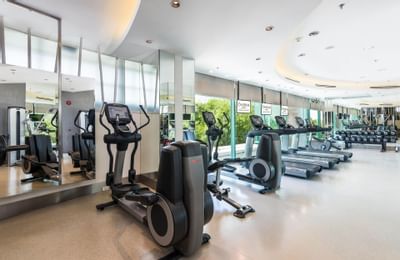 Interior of the gym with an outdoor view at Chatrium Hotel
