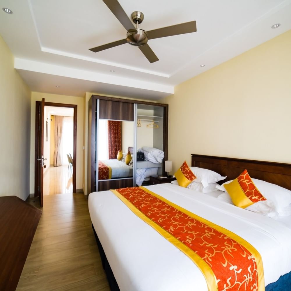 Elegant bedroom with large bed, ceiling fan, and modern decor at Lake Victoria Serena Golf Resort & Spa in Kampala.
