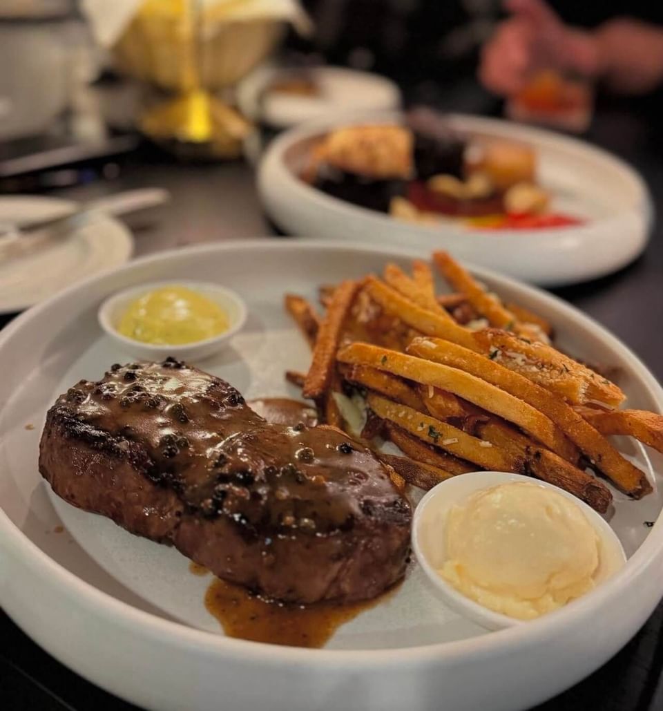 plate of well-cooked steak and crispy fries served on white dish