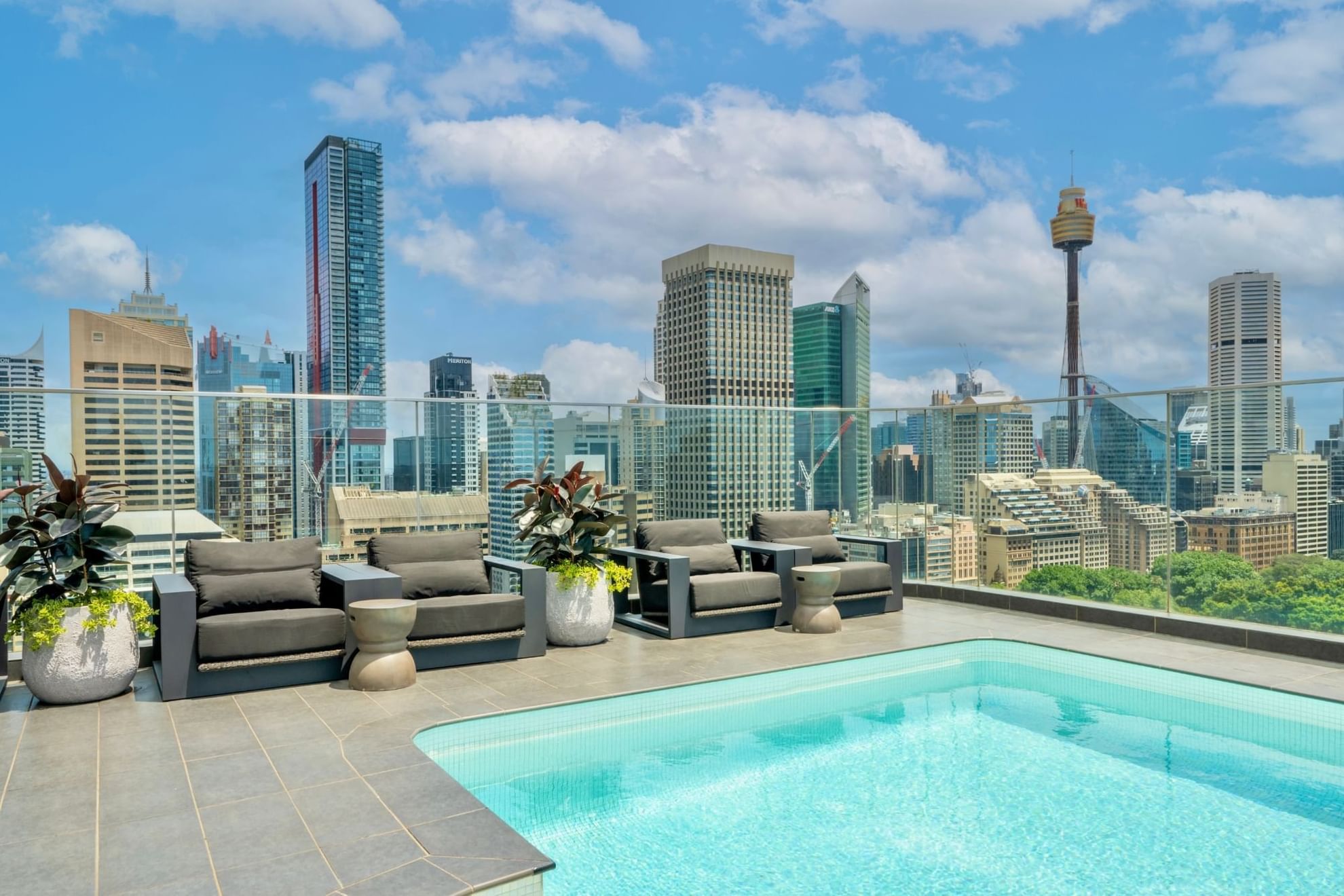 Rooftop pool area & loungers with a city view at Pullman Sydney Hyde Park