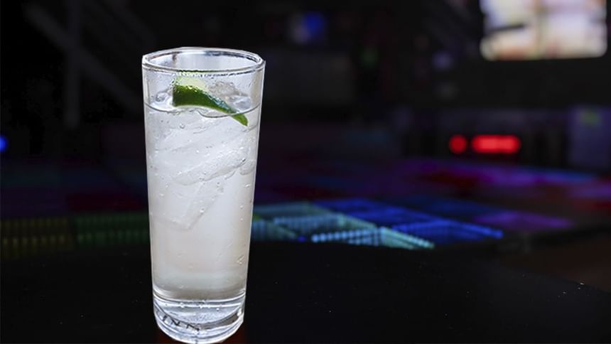 Refrescante cóctel con hielo y gajo de lima en vaso alto sobre mesa oscura en El Rollo de Araiza Palmira