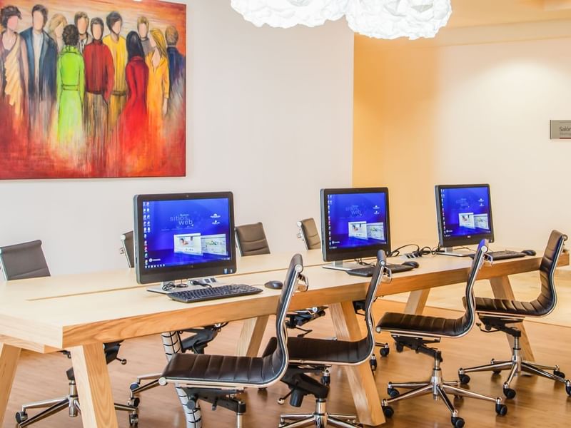 Modern lobby area with computers and chairs at Fiesta Inn