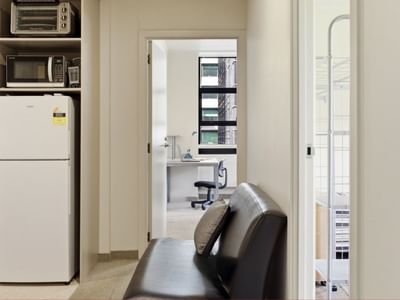 Modern room with kitchen and black couch at UniLodge Stafford House.