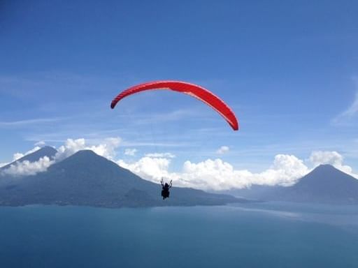 Person paragliding in the distant with a mountain view near Regis Hotel & Spa