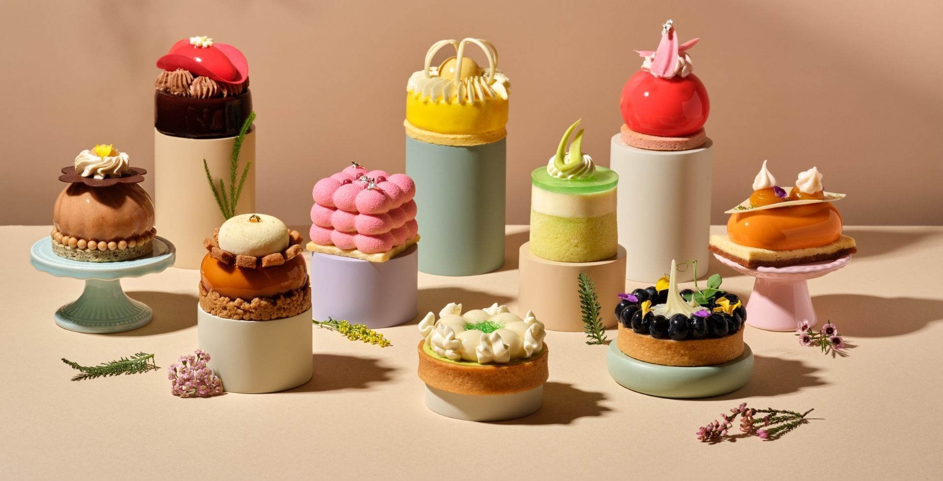 A stunning collection of colorful and intricate miniature pastries arranged artfully at the Carlton Hotel Singapore