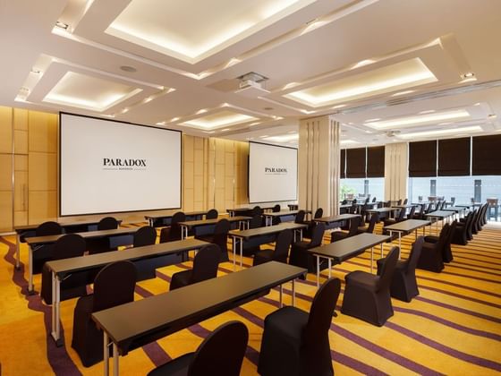 Paradox conference room with tables and chairs and white screens at Paradox Hotels and Resorts Portal