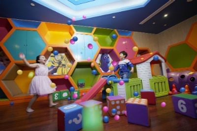two children playing happily in colourful indoor playground