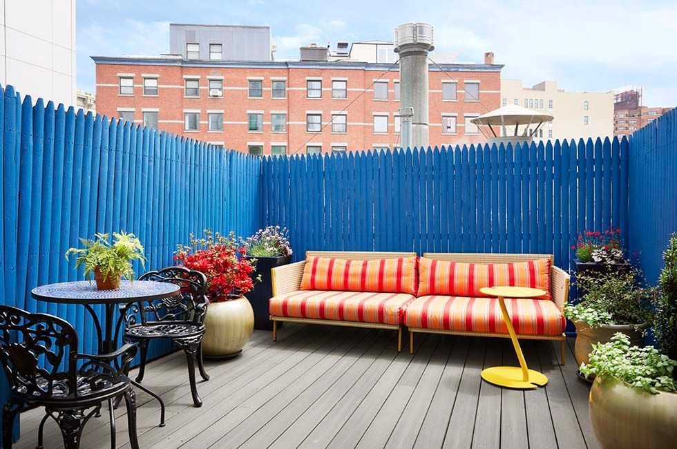 Gansevoort patio terrace with a sofa, plants and dining chairs
