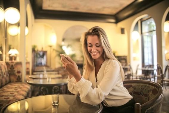 A woman scrolling on her smartphone in a restaurant