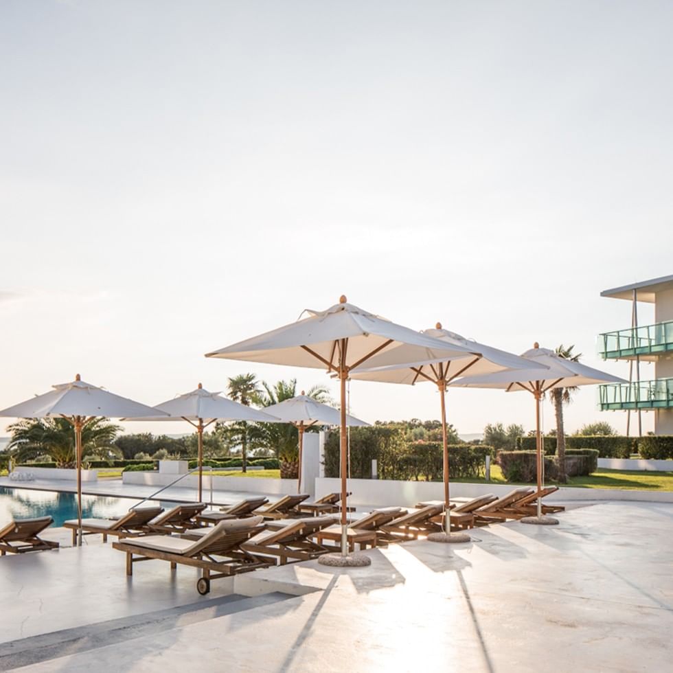 Ponuda Ostani duže, uživaj više prikazuje ležaljke i suncobrane uz bazen.
