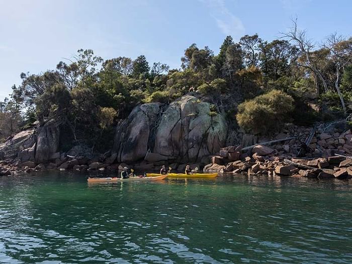 People kayaking in the Bay on a sunny day near Freycinet Lodge