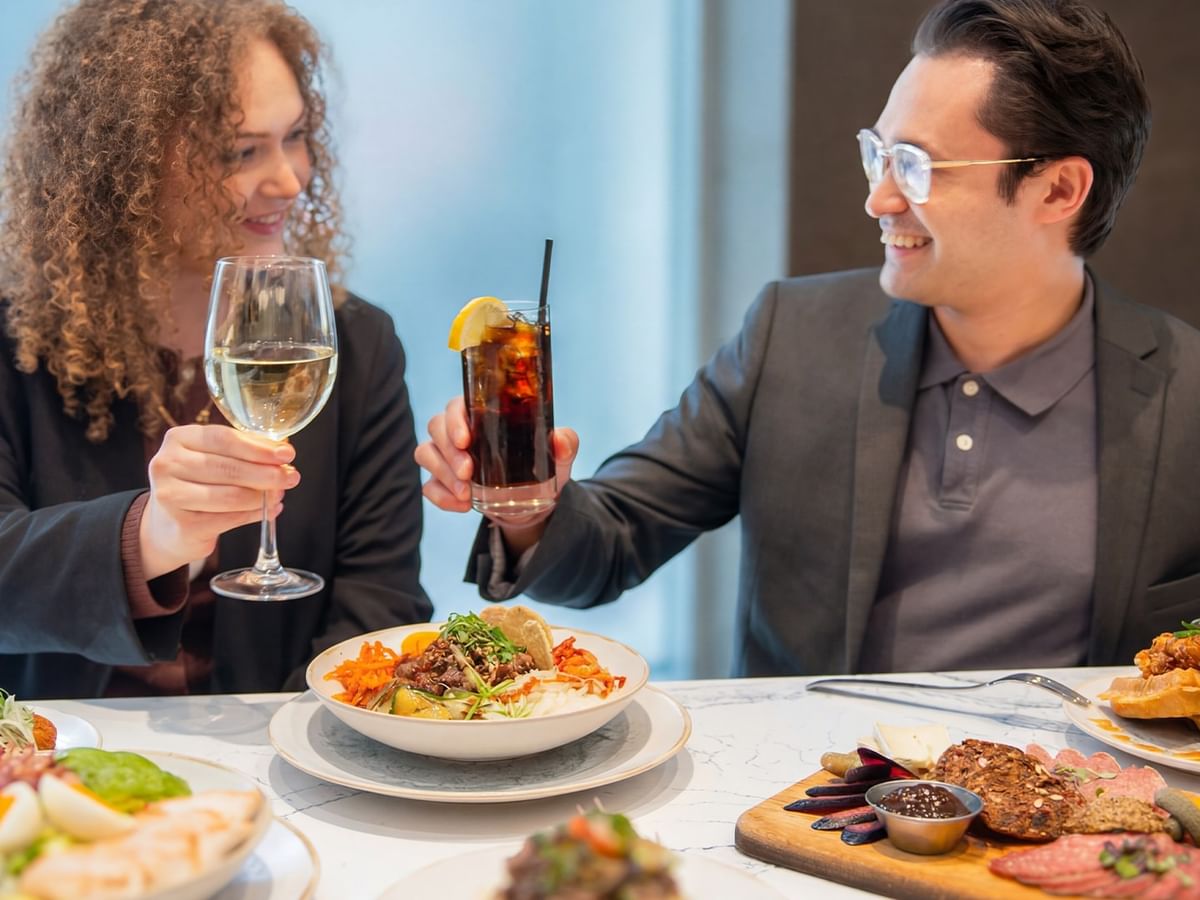 Couple toasting with drinks at Prestons Restaurant + Lounge in Vancouver.