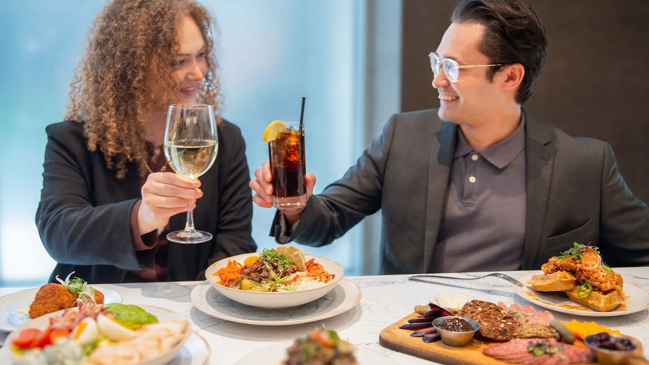 Couple toasting with drinks at Prestons Restaurant + Lounge in Vancouver.