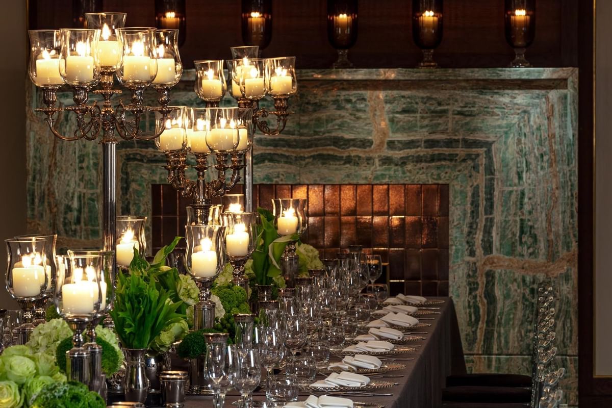 Cozy dining set up with candles & a fireplace at The May Fair Hotel's private dining room