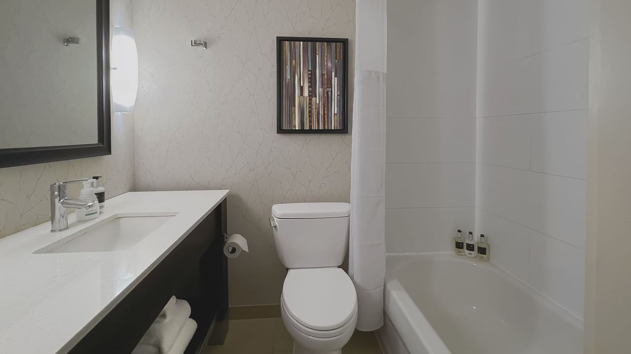 Bathroom with towels, toilet, mirror, bath and sink