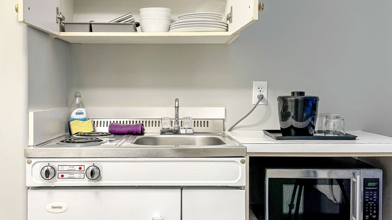 Kitchenette with microwave, sink, soap and dishes