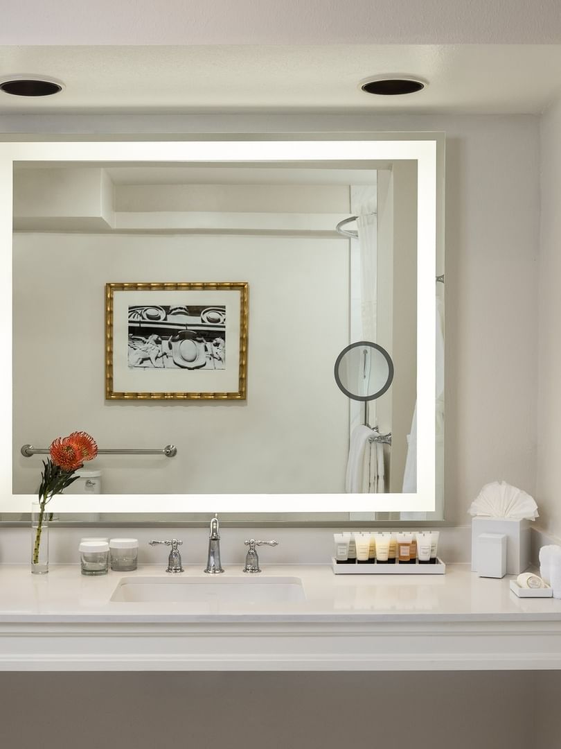 Large lighted mirror with toiletries under a recessed light in Classic Double Accessible at Warwick Melrose Dallas