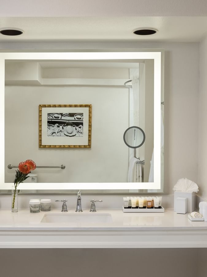 Large lighted mirror with toiletries under a recessed light in Classic Double Accessible at Warwick Melrose Dallas
