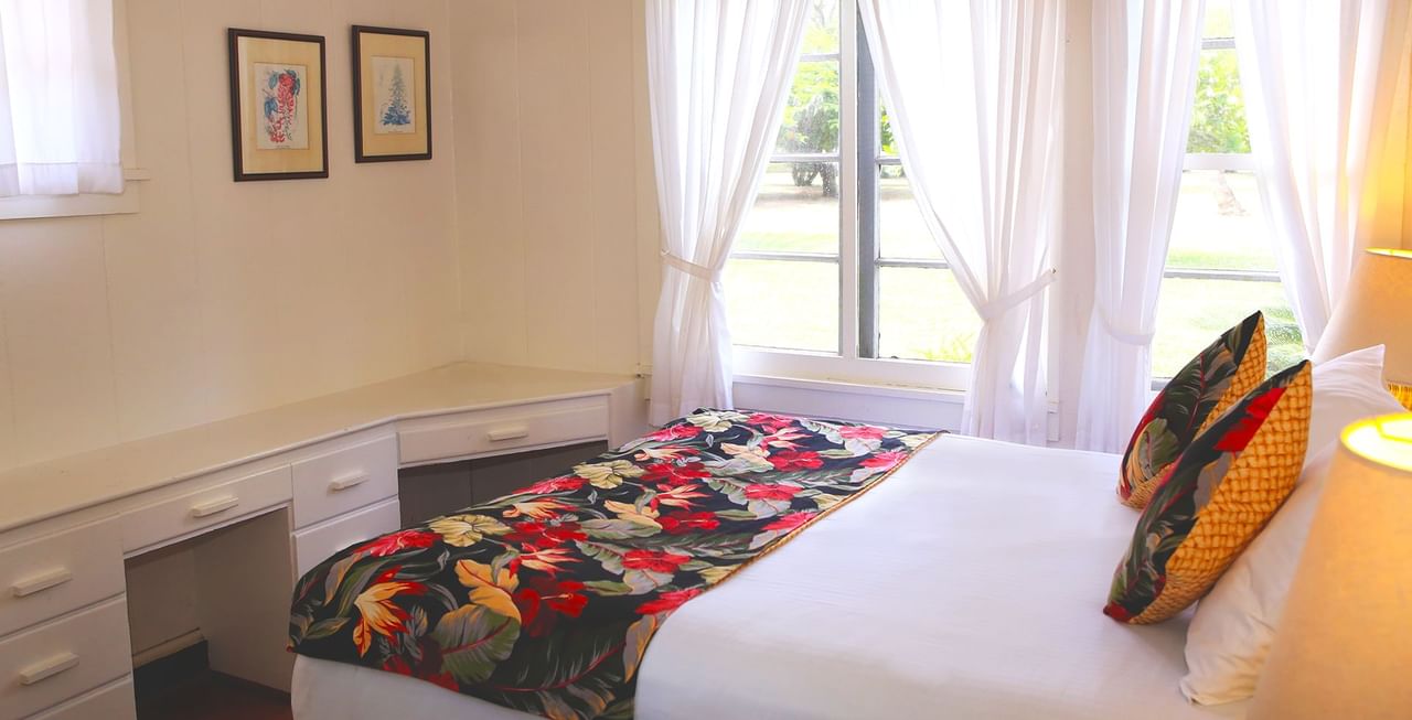Bedroom with bed, paintings, and window