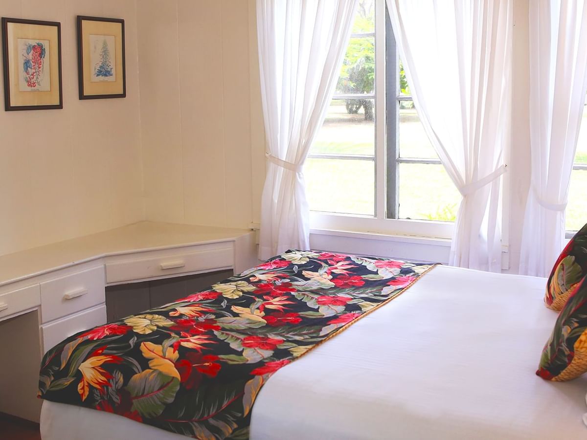 Bedroom with bed, paintings, and window