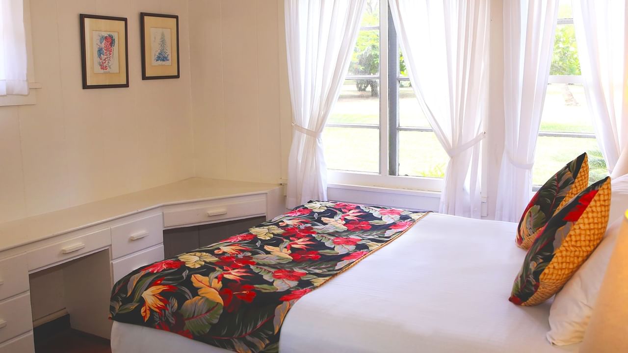 Bedroom with bed, paintings, and window