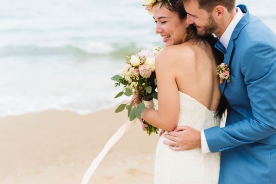 Bride & Groom cuddling on the beach near Holiday Inn Montego Bay