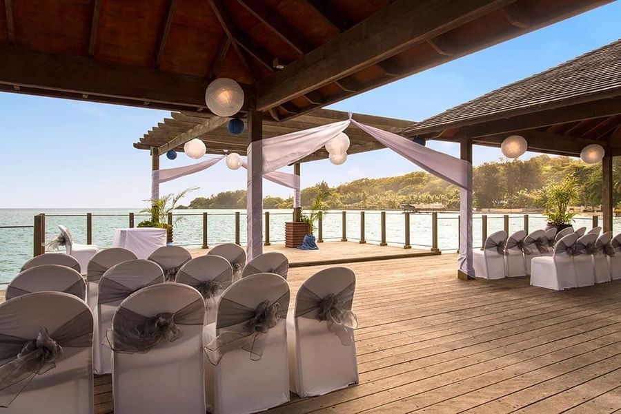 Elegant seaside wedding setup on a wooden deck with white chairs and paper lanterns at warwick le lagon-vanuatu