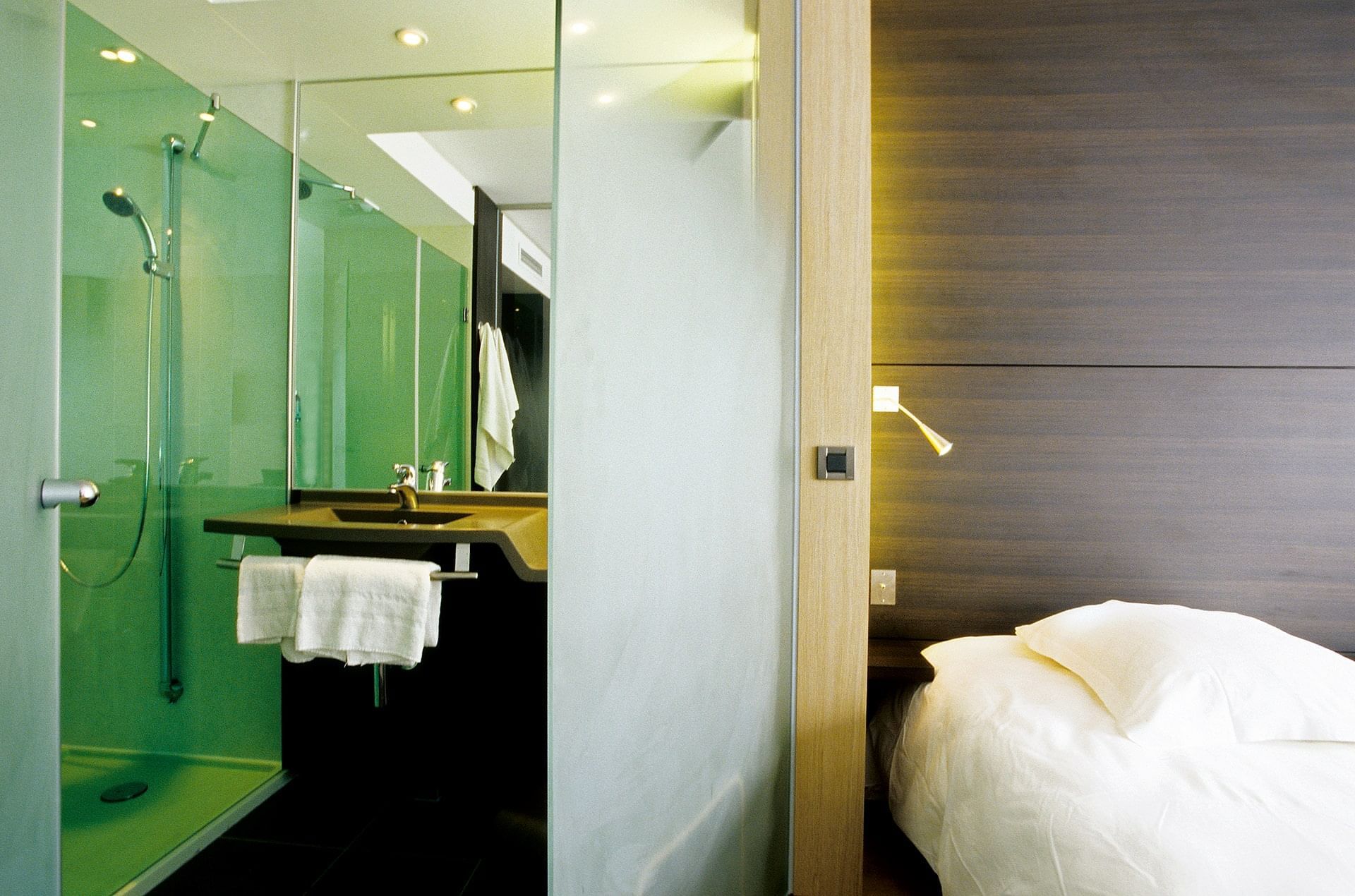 Coin lavabo dans la salle de bain près du lit dans une chambre à l'Oceania Quimper