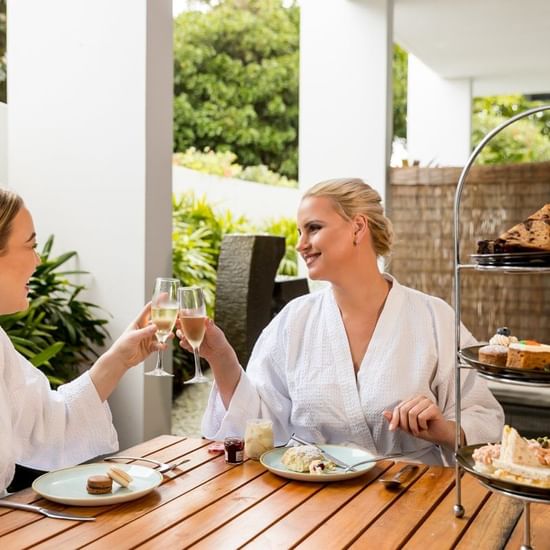 Two ladies cheering glass of wine at Vie Spa Magenta