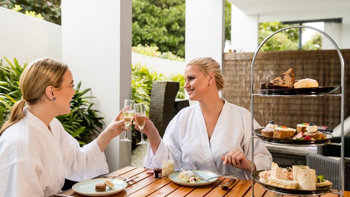 Two ladies cheering glass of wine at Vie Spa Magenta