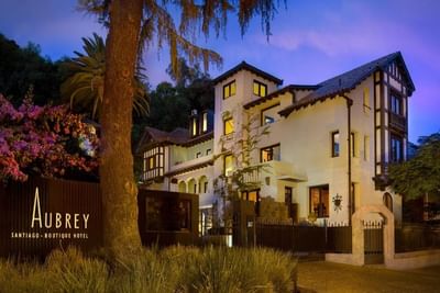 Vista frontal de la entrada del Hotel Aubrey al anochecer, con el cartel del hotel, hoteles históricos Santiago Chile