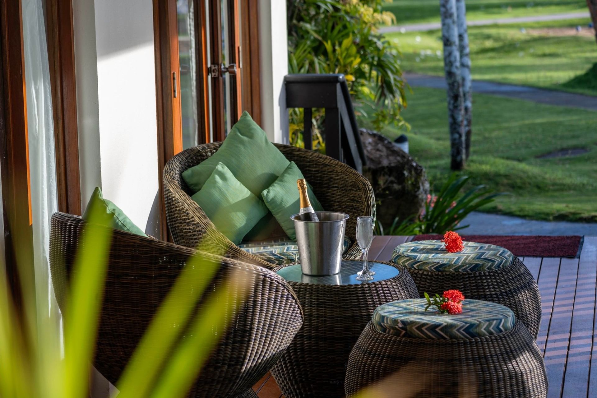 Wicker chairs by a champagne bucket on a table surrounding a patio deck in One-Bedroom Villa at The Naviti Resort - Fiji