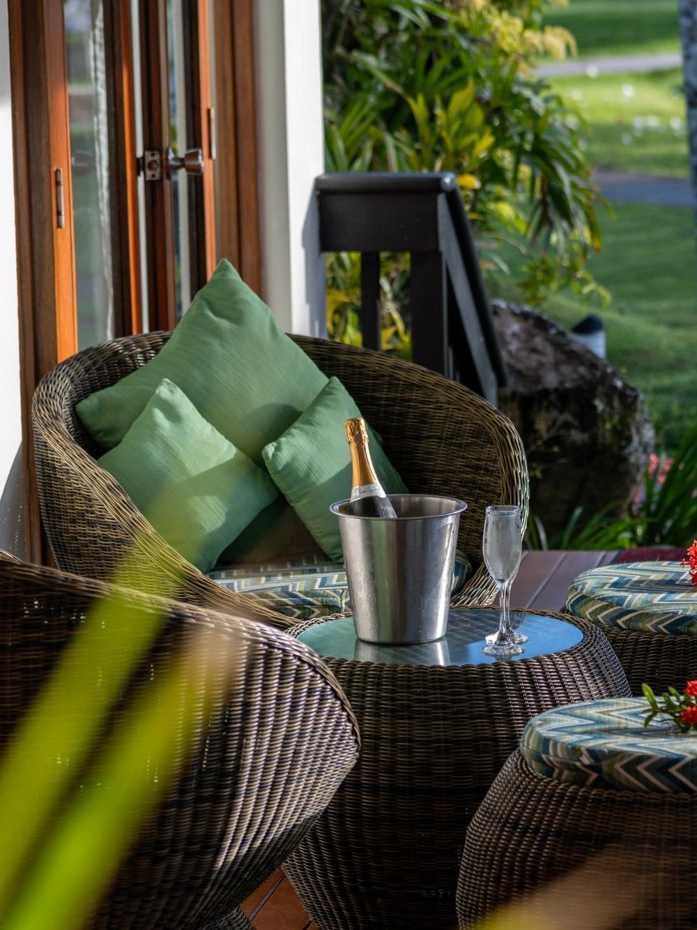 Wicker chairs by a champagne bucket on a table surrounding a patio deck in One-Bedroom Villa at The Naviti Resort - Fiji