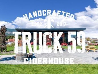 Truck 59 Cider House sign with a building and outdoor seating area.