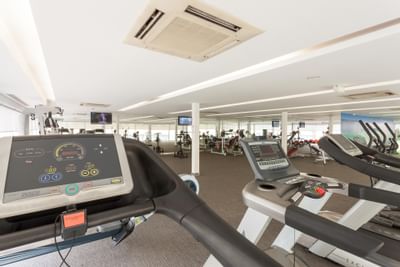 Exercise equipment in the Gymnasium with carpeted floors at Hotel Presidente Luanda