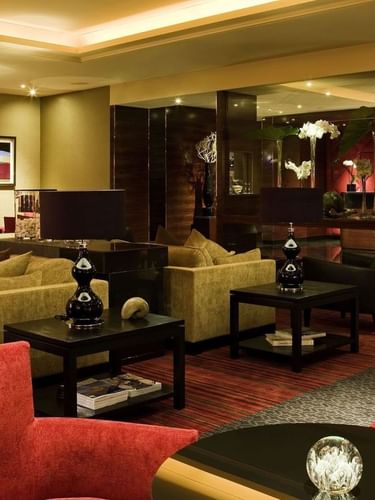 Plush brown sofas by black tables under ceiling lights in Bar “Le W” at Warwick Paris Champs Elysées