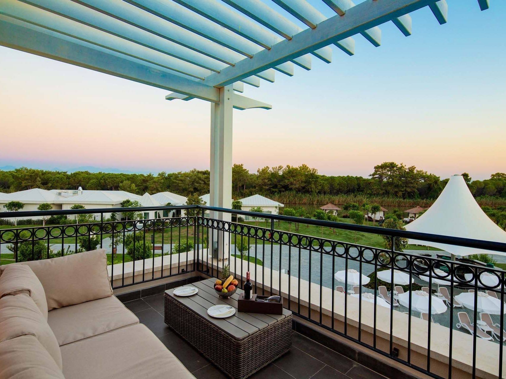 Family Pool Suite Balcony with lush greenery view at Titanic Deluxe Golf Belek