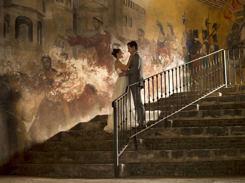 Wedding couple posing by a mural at Fiesta Americana Hotels