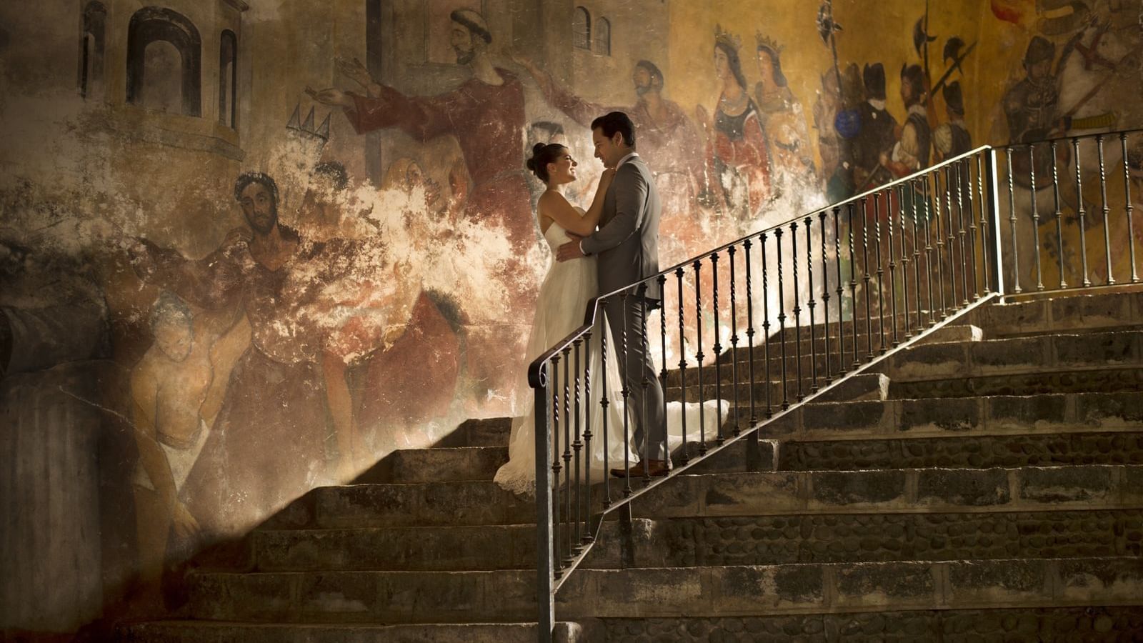 Wedding couple posing by a mural at Fiesta Americana Hotels